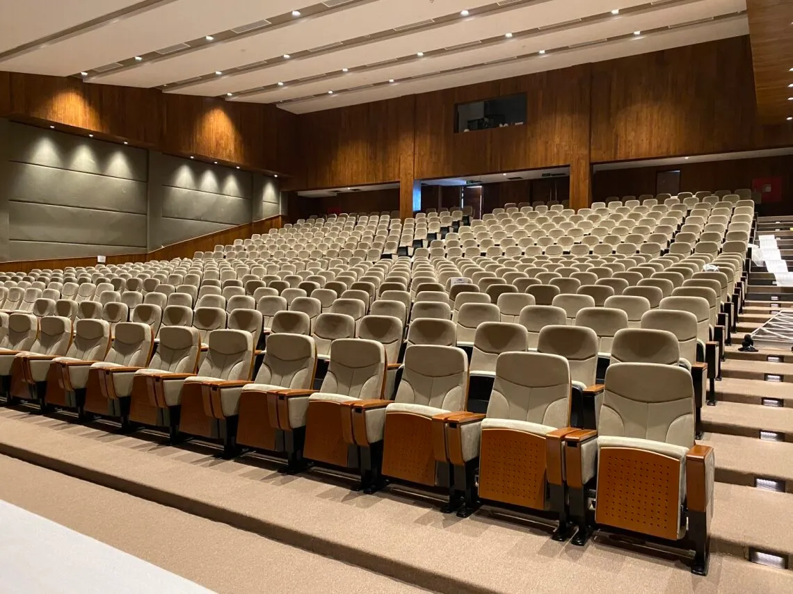 Professionally lit auditorium with stage lighting and audio setup